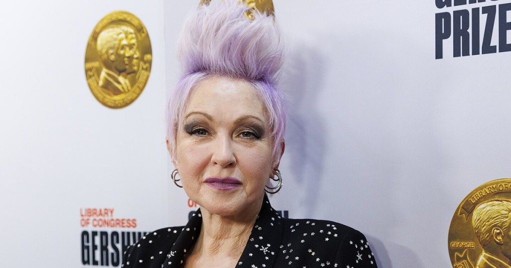 Cyndi Lauper, with lavender upswept hair and a black star-studded jacket, on the red carpet at the Library of Congress Gershwin Prize concert