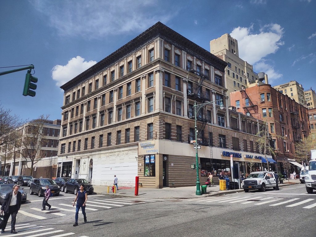 The five-story 1895 corner building at Columbus Avenue and West 84th Street with a Gristedes supermarket on the ground floor and the lower former movie-theater building beside it